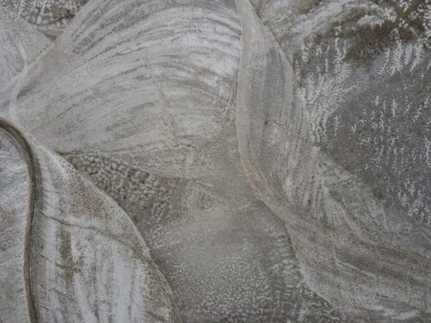 A winding river is seen in the bottom left of the photograph surrounded by deposits showing the river's previous migrations