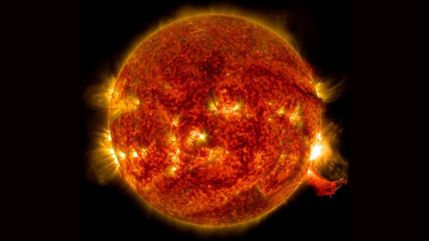 A photograph of the sun with a bright solar flare in its lower right side