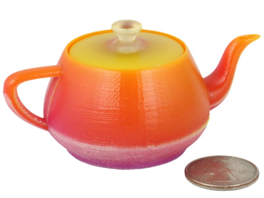A small teapot made of yellow, orange and purple materials which gradually transition like a sunset
