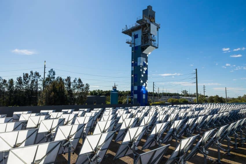 Line of mirrors in field with tower