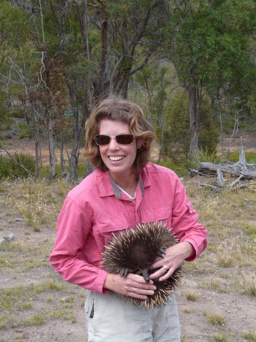 Christine cooper holding echidna and smiling at camera