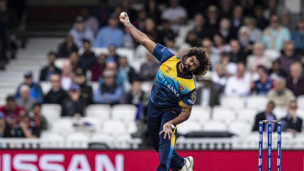 bowler bowling with outstretched arm in stadium