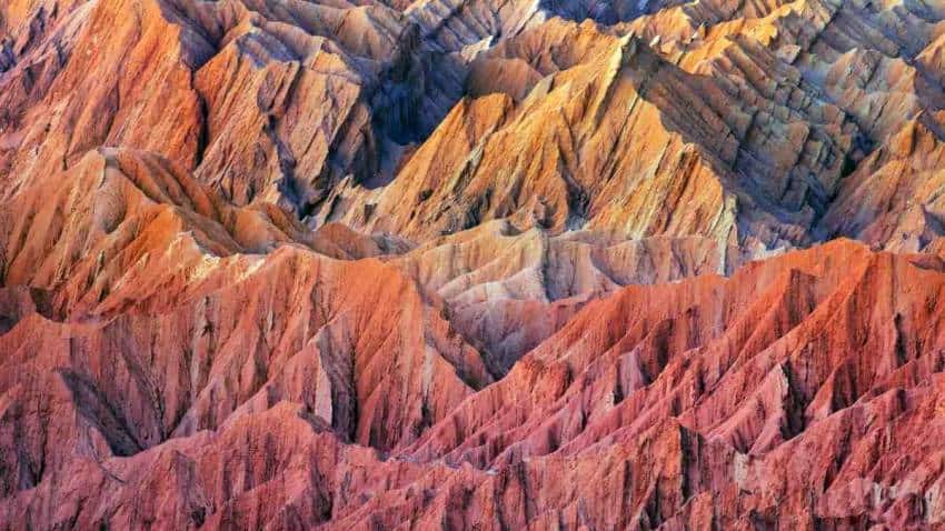 A series of jagged peaks coloured red, orange and gold. The desert where the microbes were found.