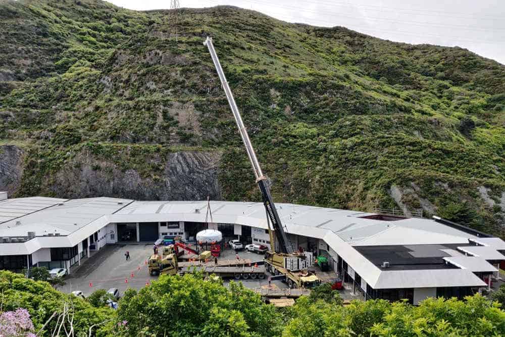 Crane delivering machine in new zealand mountains