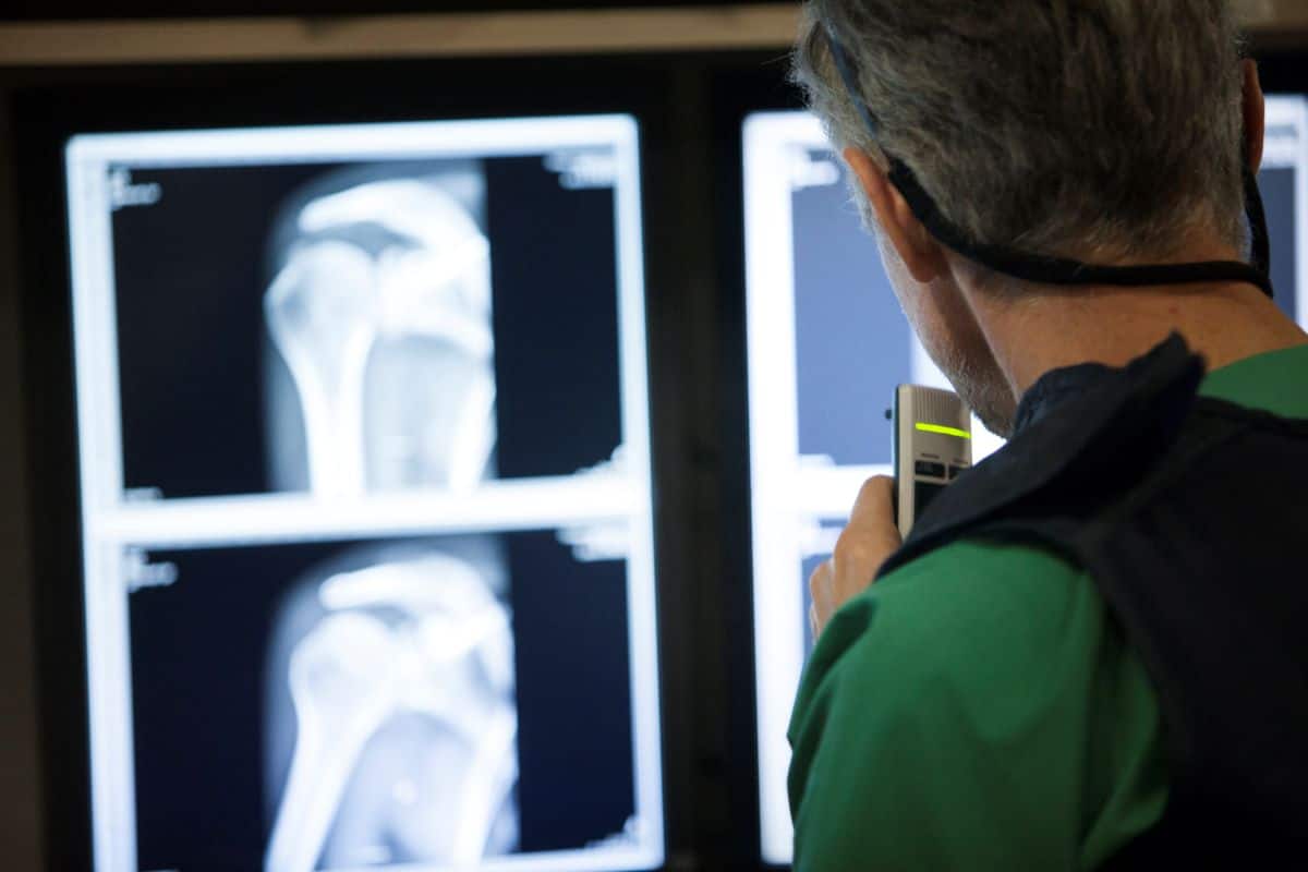 A doctor uses an audio device to record descriptions of a broken bone. (Photo by Sebastian Willnow/picture alliance via Getty Images)