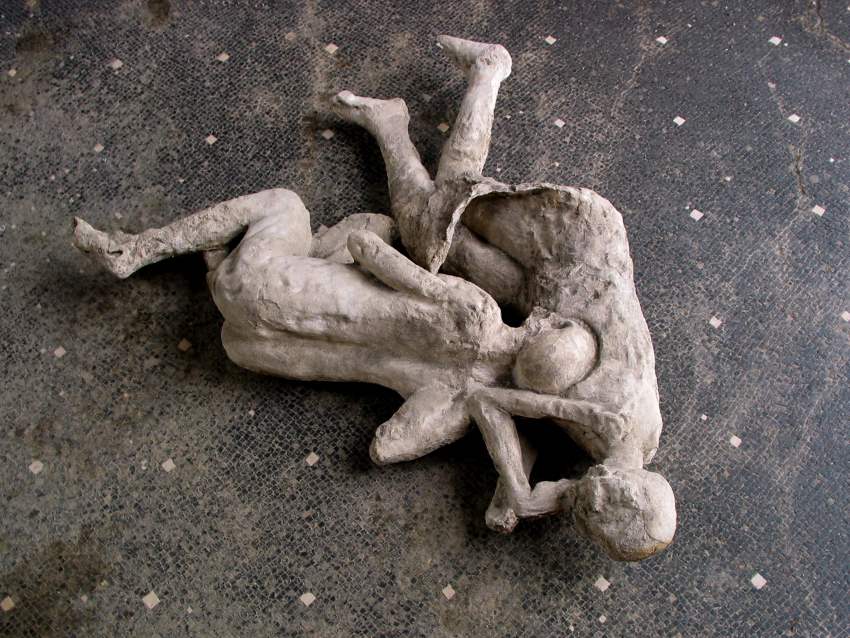 A photograph of plaster casts of 2 people curled up together on the ground