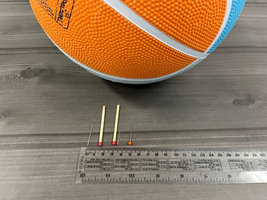 A basketball, matches, pins of various sizes representing the sun and the planets.