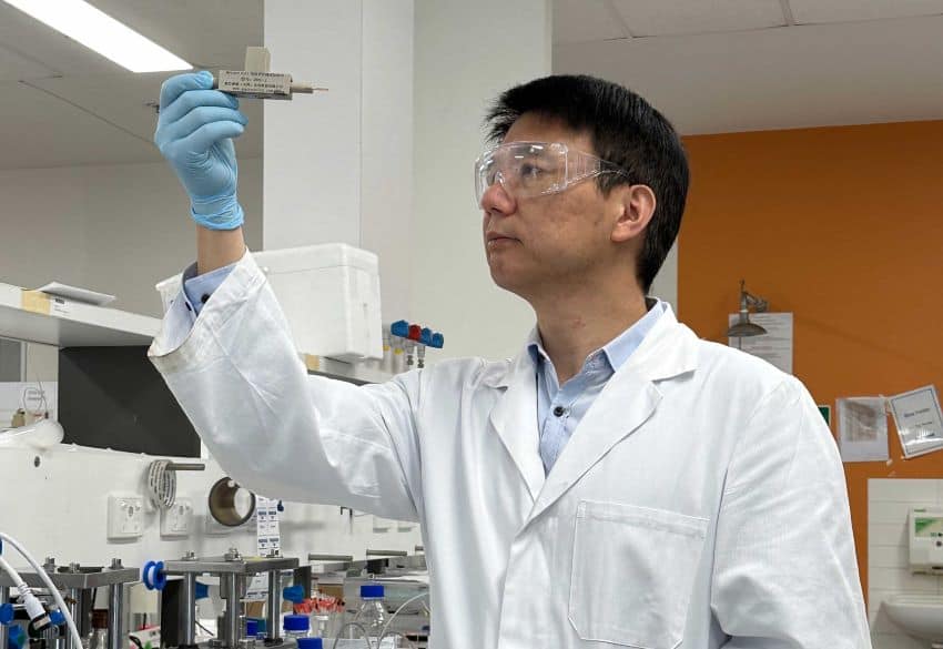 Person in lab holding up prototype battery