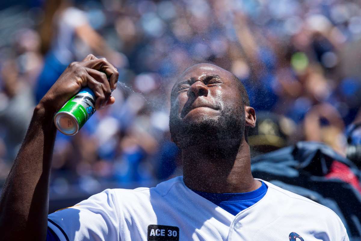 Lorenzo Cain #6 of the Kansas City Royals sprays sunblock on his face before a game in Kansas City, Missouri.