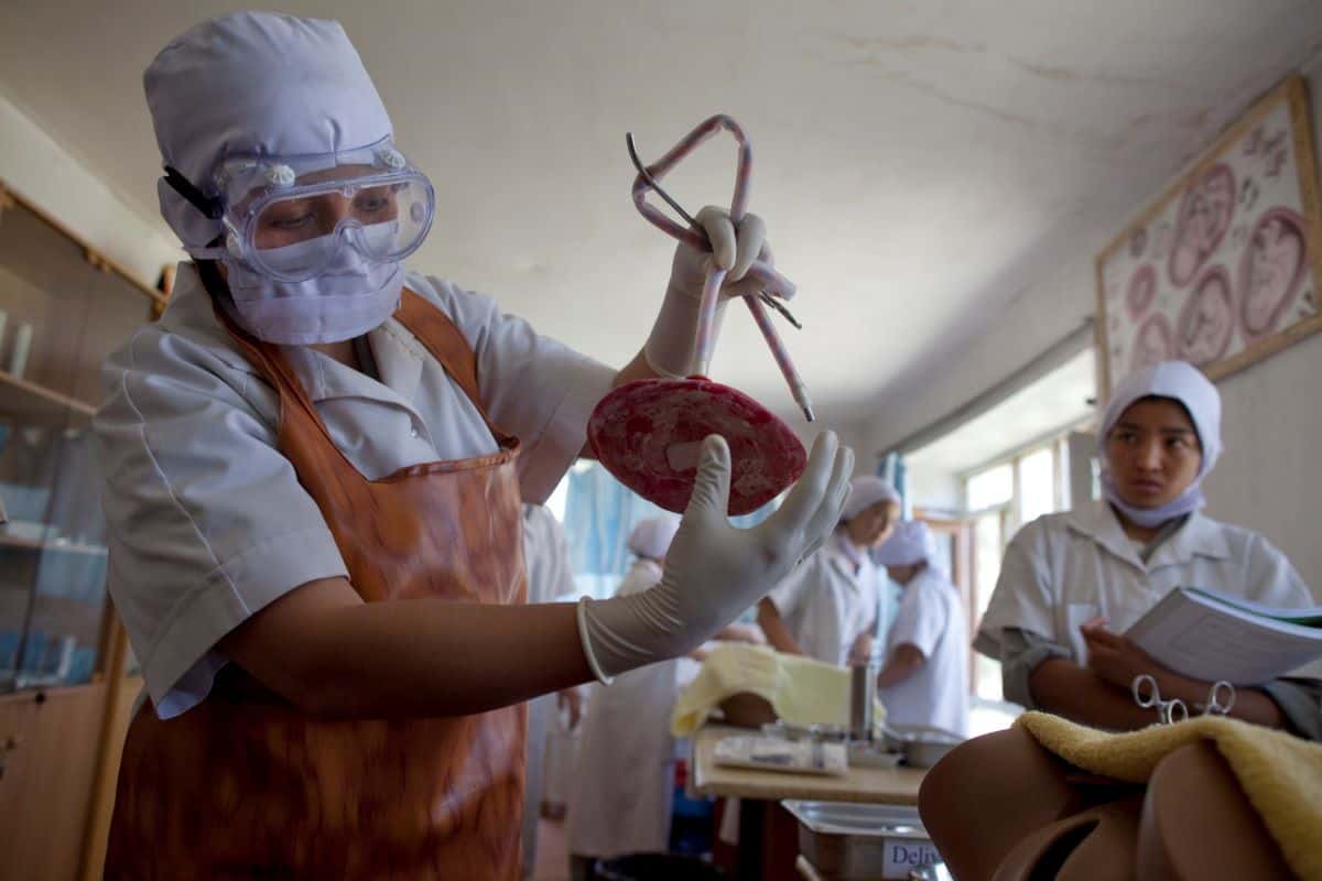 An Afghan midwifery student holds an imitation placenta as she practices during classroom training September 3, 2009.