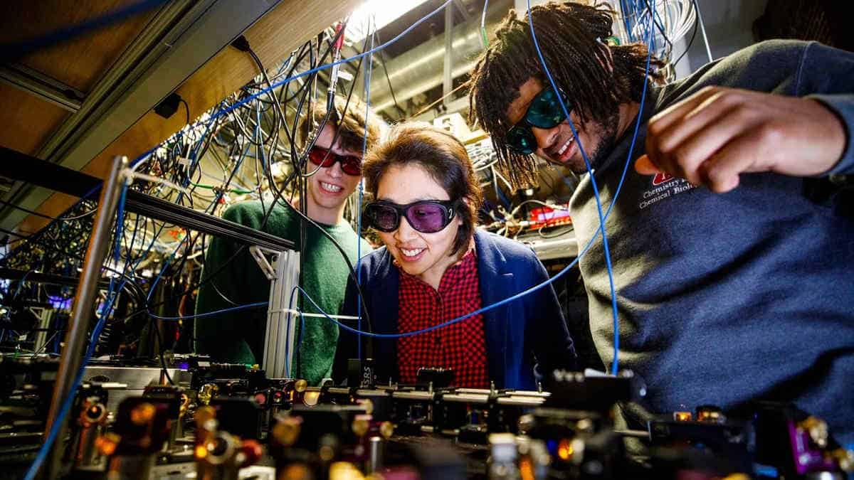 Three excited scientists looking at device