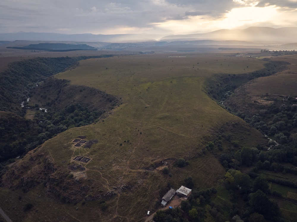 Aerial photograph of field and two gorges with mountains in distance