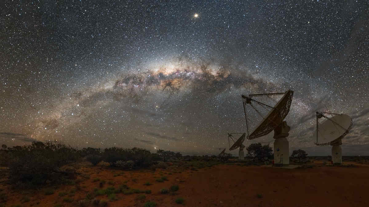 Radio telescope array in desert night sky milky way