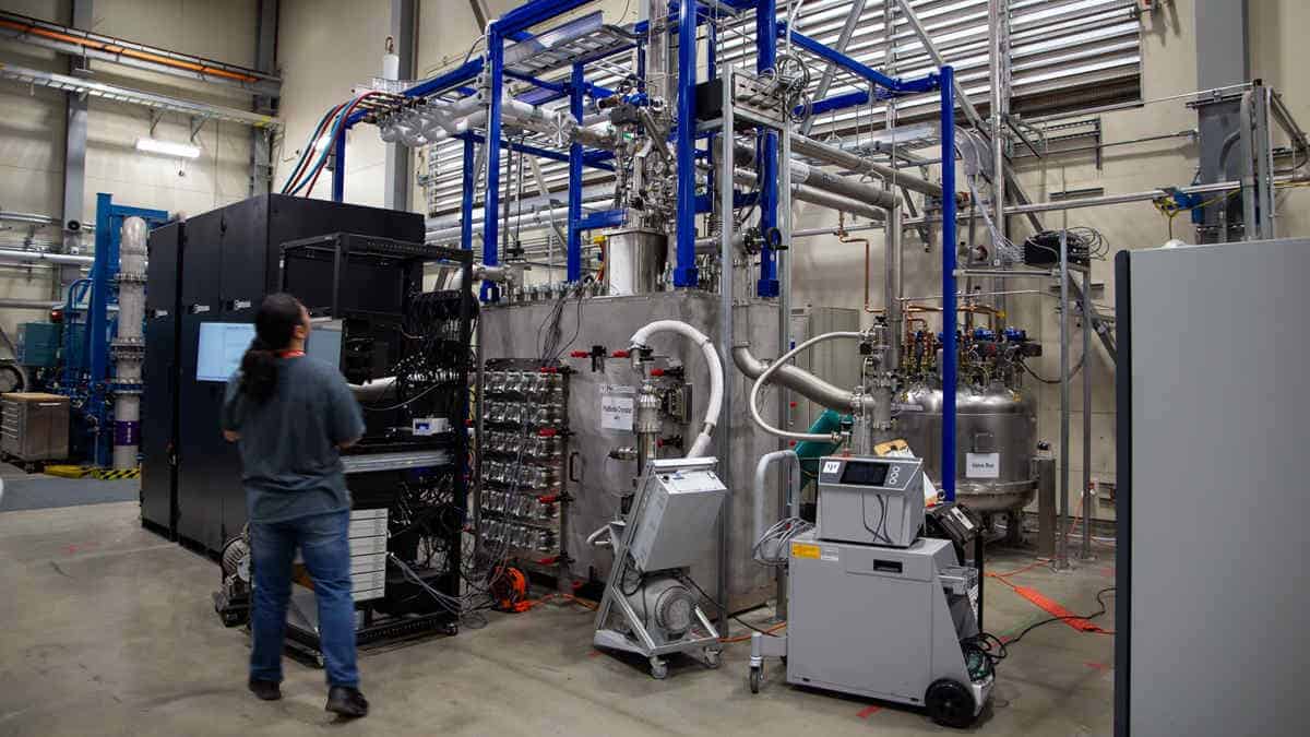 Scientist walking past large cryo machine in lab