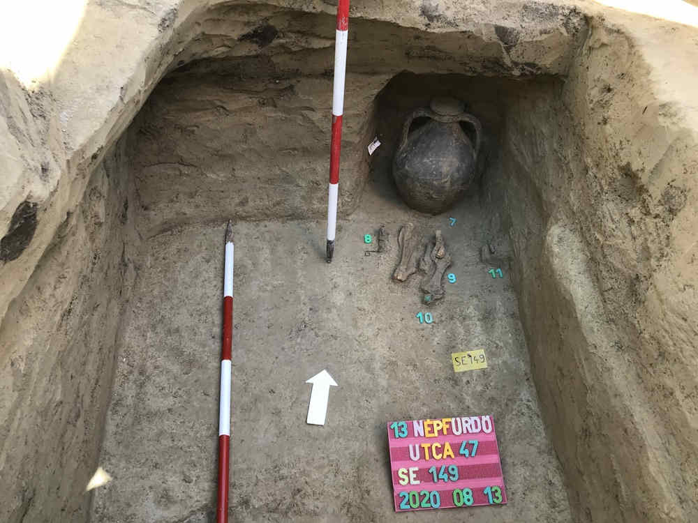 Burial photo showing bones vase and measuring poles