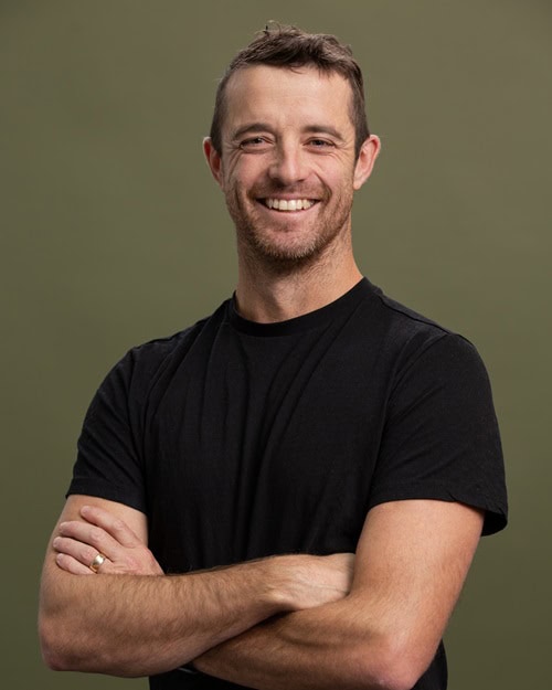 Smiling man in black t shirt brown background