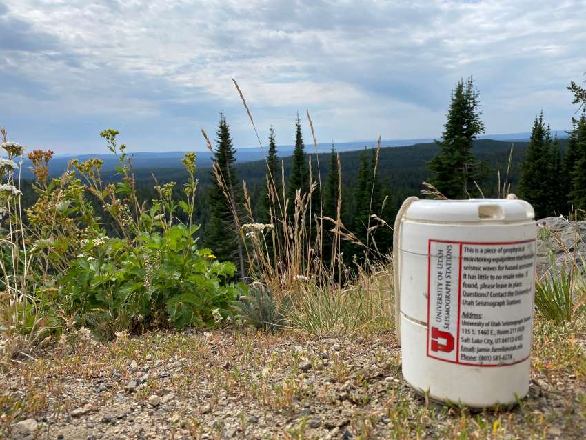 A cylindrical plastic device placed on a hill overlooking forest