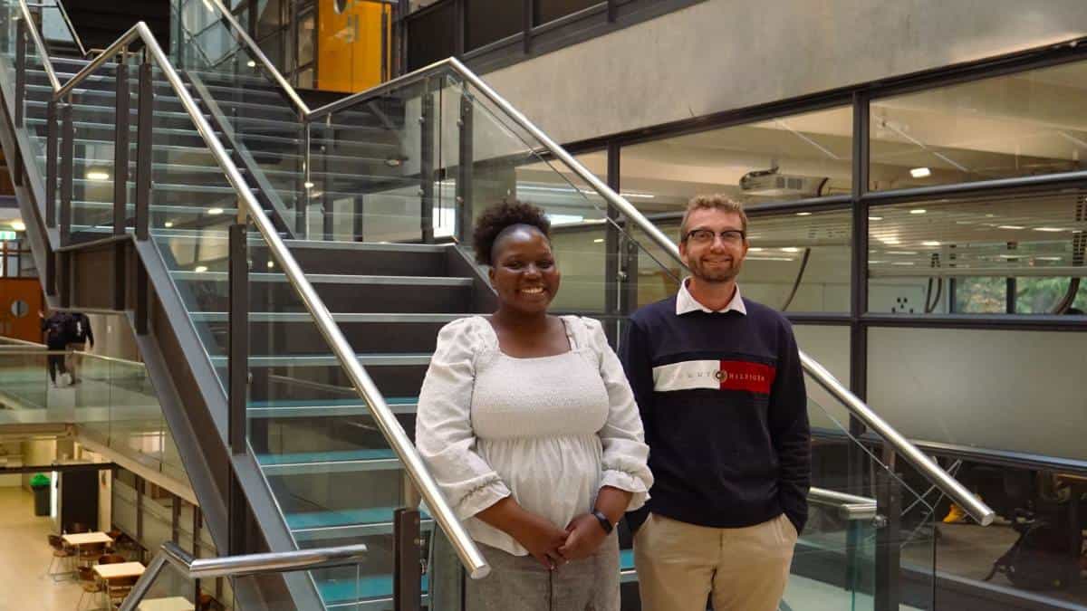 Two people stand at the foot of staircase