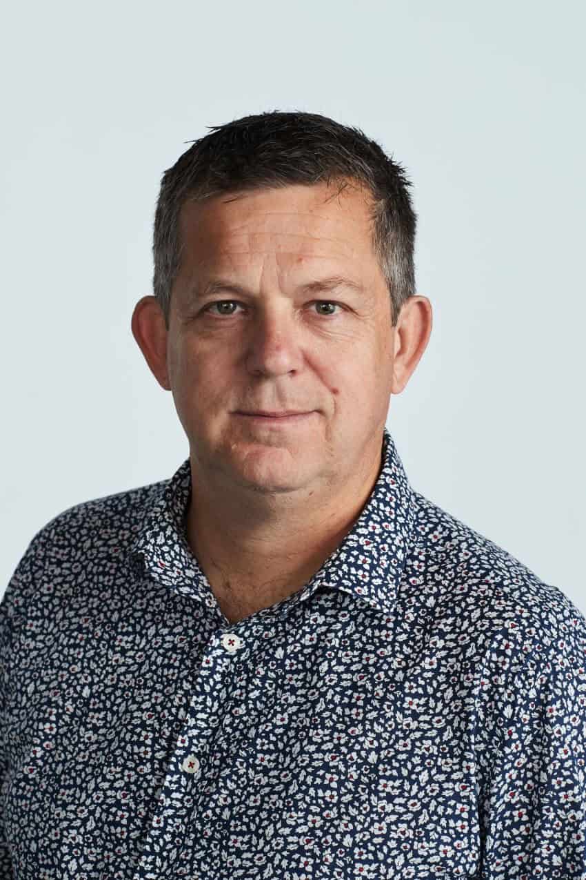 Head and shoulders shot of robert brooks. Male with short dark hair wearing a blue and white floral shirt.
