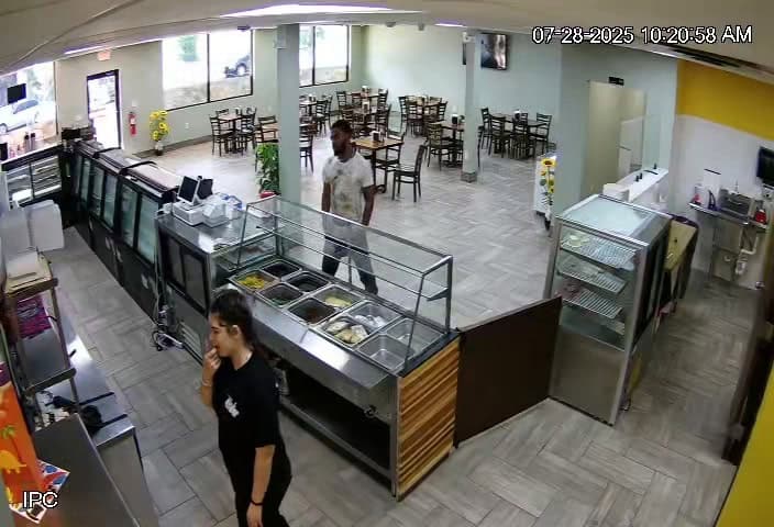 man waits to speak to employee behind counter. He is a thief and tells her he forgot the key to collect the used cooking oil.
