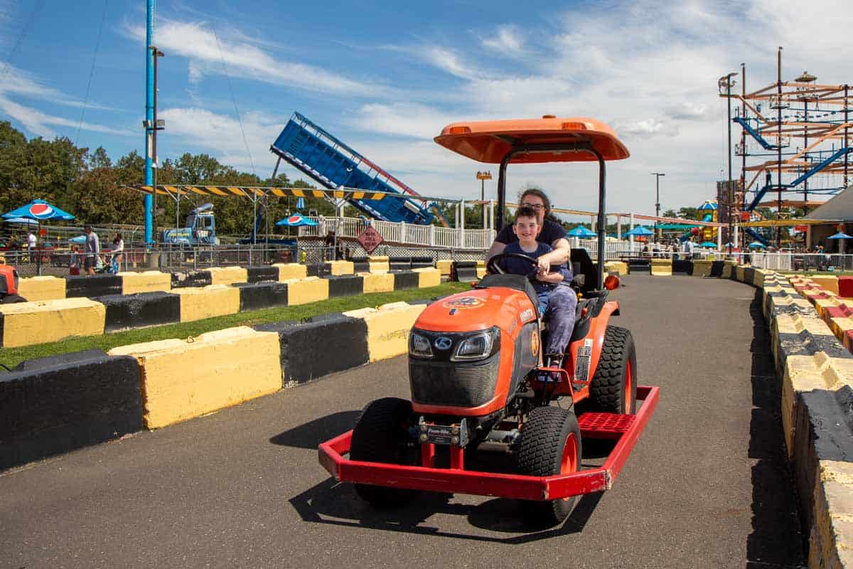Mother and child drive a real tractor at Diggerland.