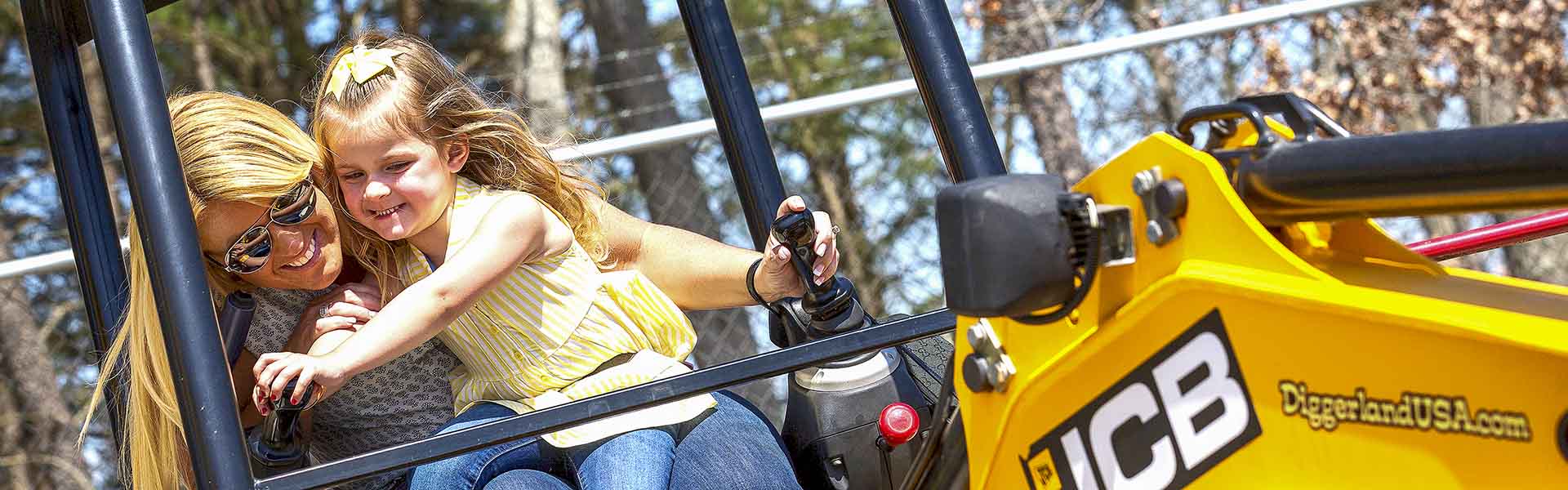 Mother and daughter use a real JCB excavator at Diggerland for fun. Just one of the many great attractions.