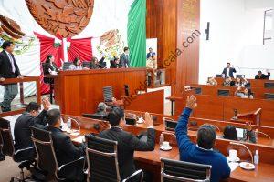 Feliz, democrático, unas personas levantando la mano en una sesión de una sala de sesiones de una sala de sesiones de un congreso en Tlaxcala, México.