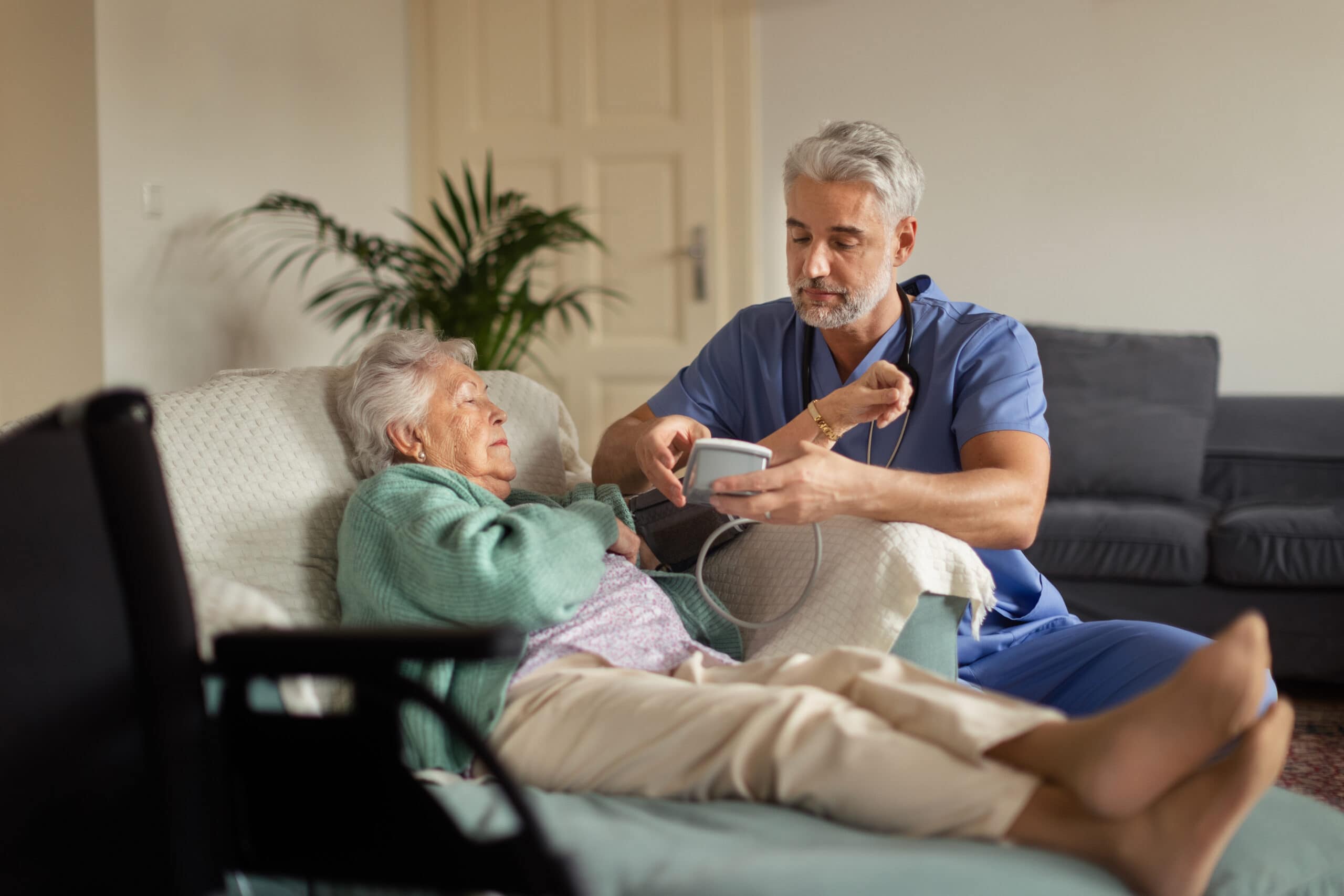Caregiver doing regular check-up of senior woman in her home.