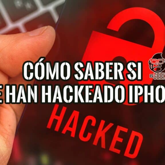 Una mano sujetando un iPhone con la palabra "HACKED" en rojo sobre una pantalla oscura. En la parte superior, se lee "Cómo saber si me han hackeado el iPhone".