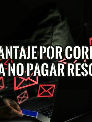 Ciberdelincuente encapuchado realizando un chantaje por correo electrónico desde su portátil.