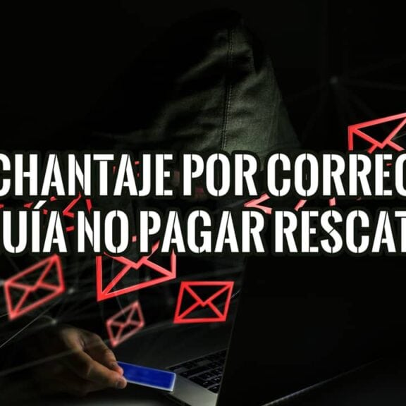 Ciberdelincuente encapuchado realizando un chantaje por correo electrónico desde su portátil.