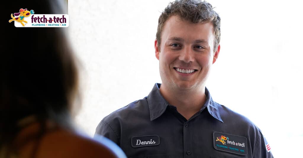 Dennis, a friendly Fetch‑A‑Tech team member in uniform and name tag, smiles warmly as he prepares to help a customer with insulation solutions for their Las Vegas home. The Fetch‑A‑Tech logo is visible in the corner, reflecting our family-owned commitment to comfort and honest service.