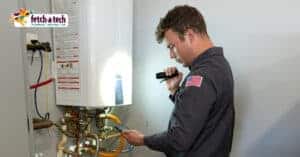 A friendly Fetch‑A‑Tech technician carefully inspects a water heater with a flashlight, using a handheld device to ensure everything is working safely and efficiently. The company’s logo is proudly displayed in the top left corner, highlighting their trusted, family-owned service in Las Vegas dedicated to keeping your home comfortable and worry-free.