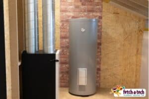 A water heater and ventilation unit are neatly installed in a cozy Las Vegas home with wood paneling and brick walls. The Fetch‑A‑Tech logo in the corner reflects our family-owned commitment to comfort, reliability, and helpful service for our neighbors.