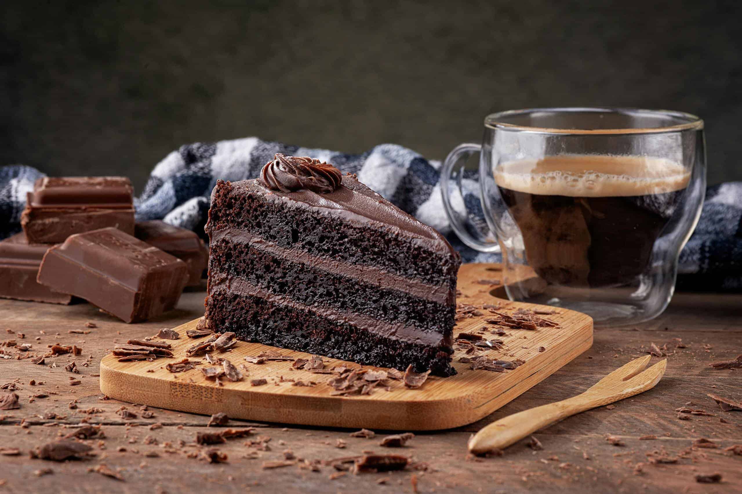 Indulge in a rich chocolate cake slice paired with a cup of coffee, perfect for dessert lovers.