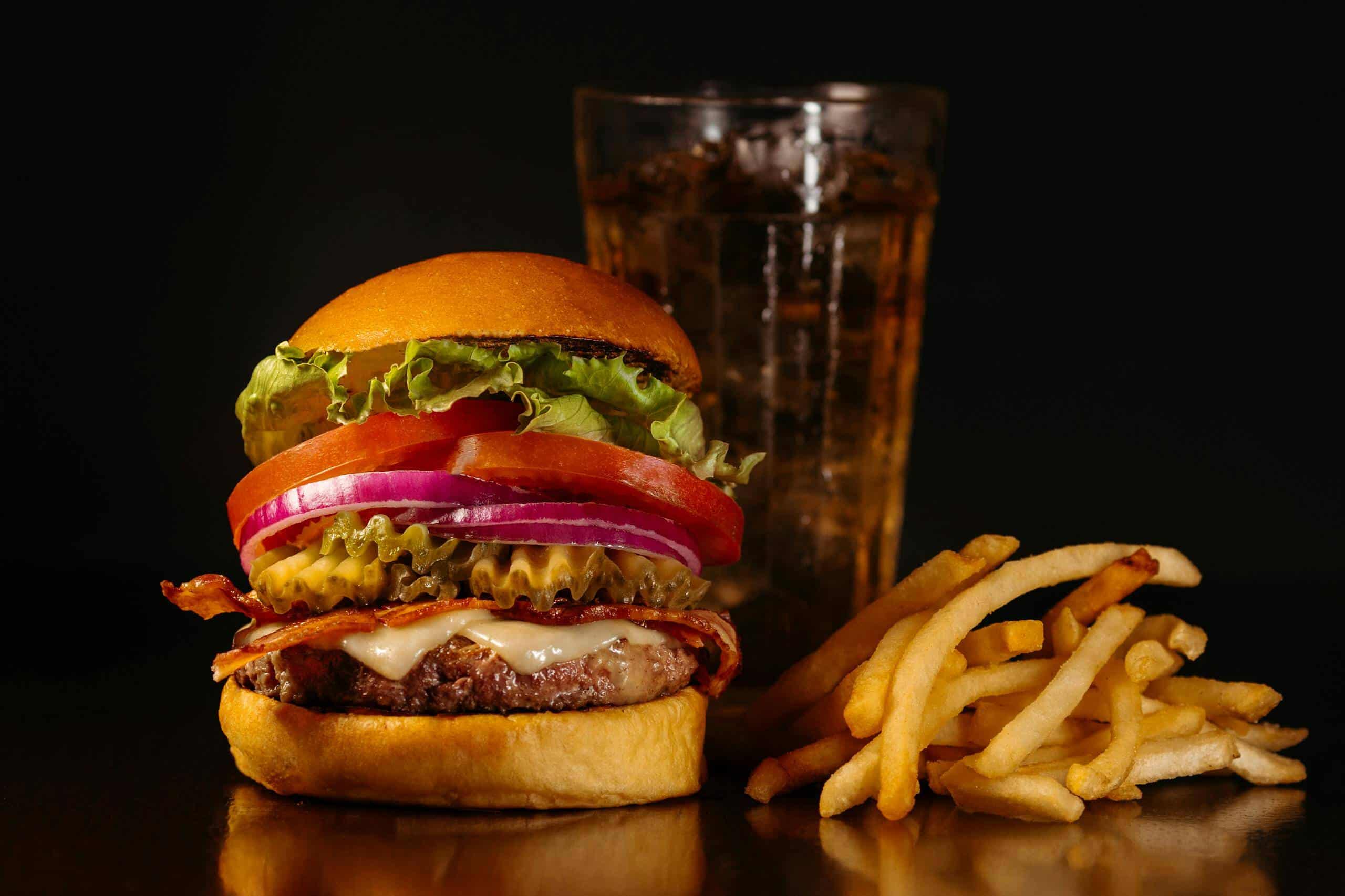 Mouthwatering cheeseburger with bacon served with fries and cola. Perfect for fast food lovers.