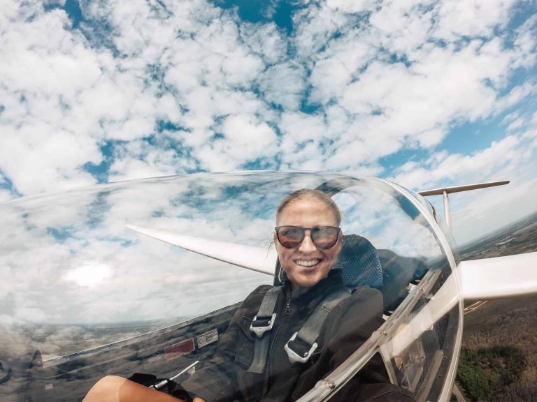 A 30 year old woman pilot smiling inside the cockpit