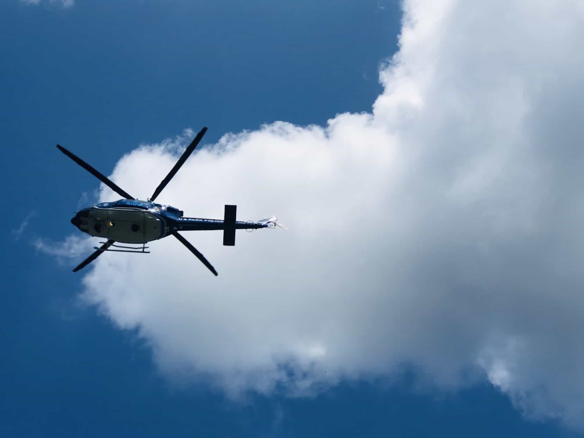 A helicopter's blades spinning fast as it cruises