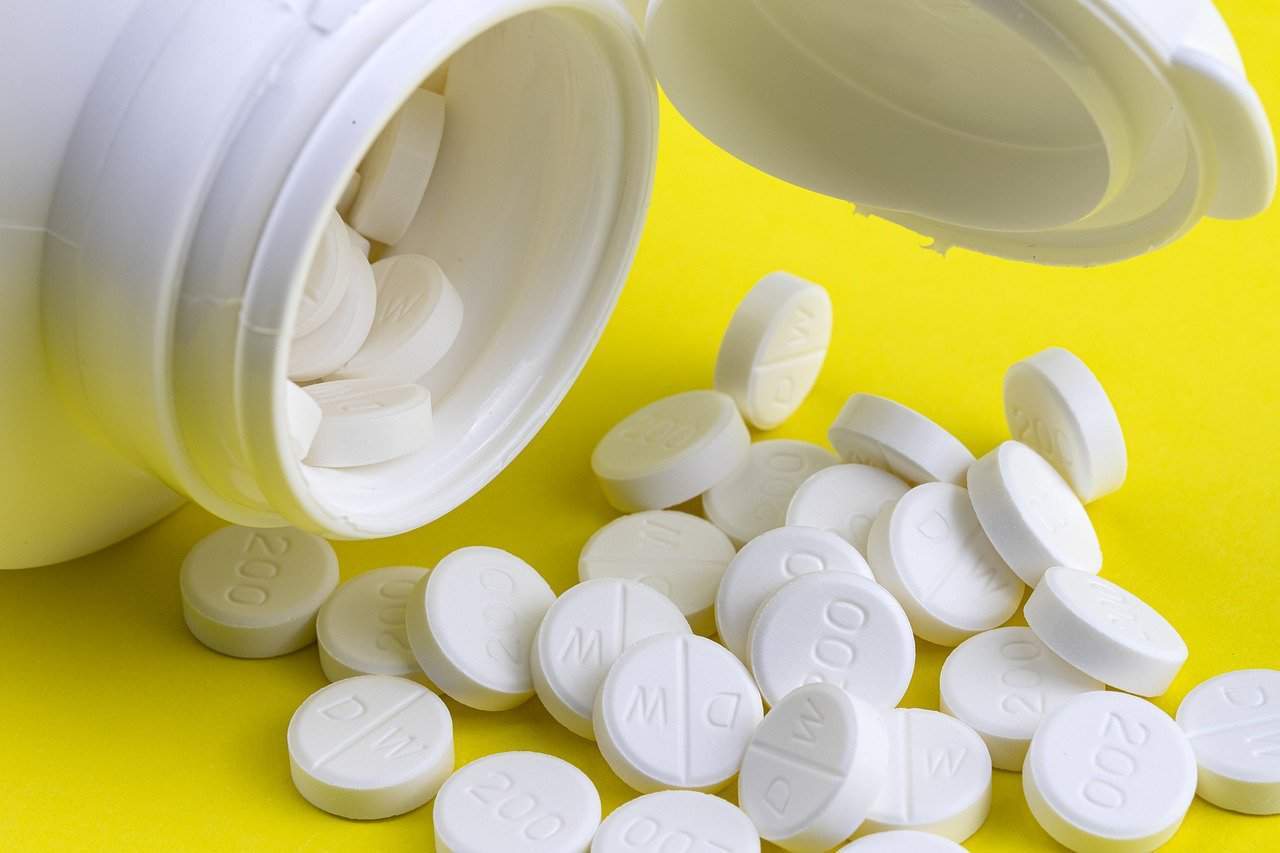 A bottle of pills and pills next to it