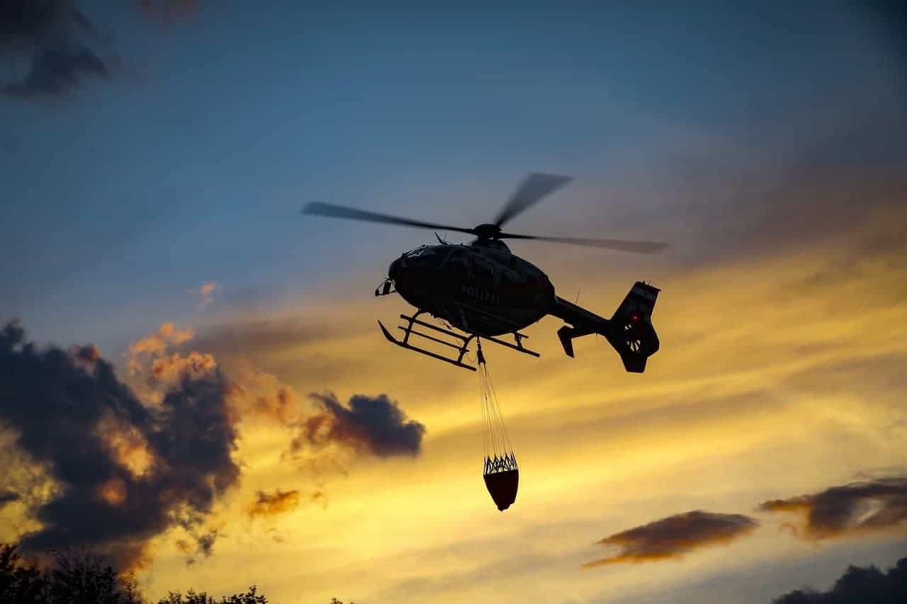A heavy helicopter flying as the sun sets