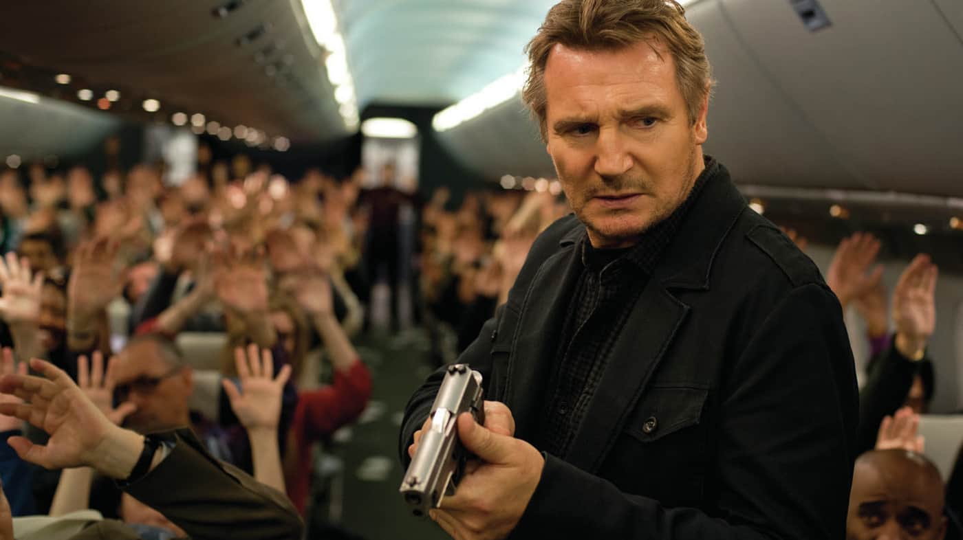 An Air Marshal holding a gun on a plane