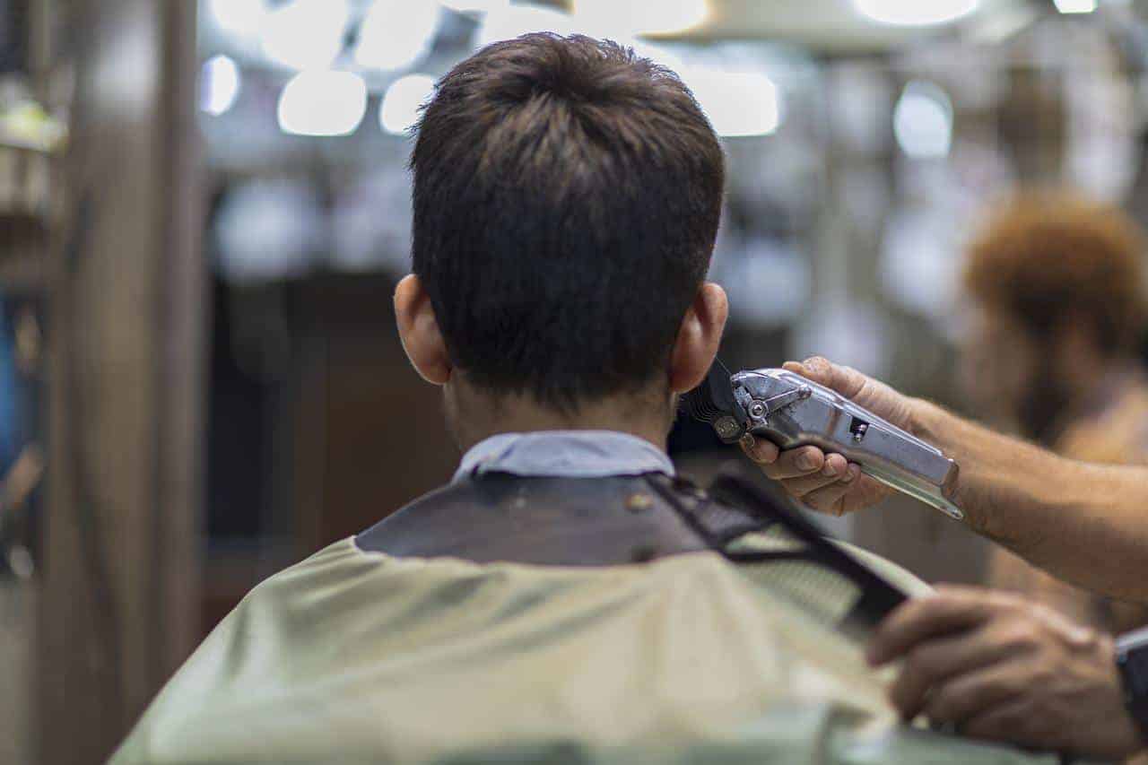 A man getting a haircut with hair clippers