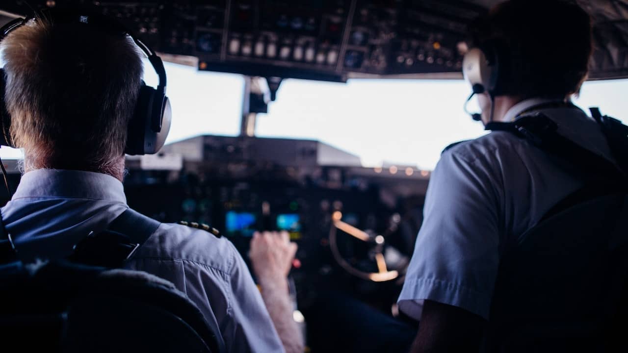 A captain and co-pilot sitting in the cockpit
