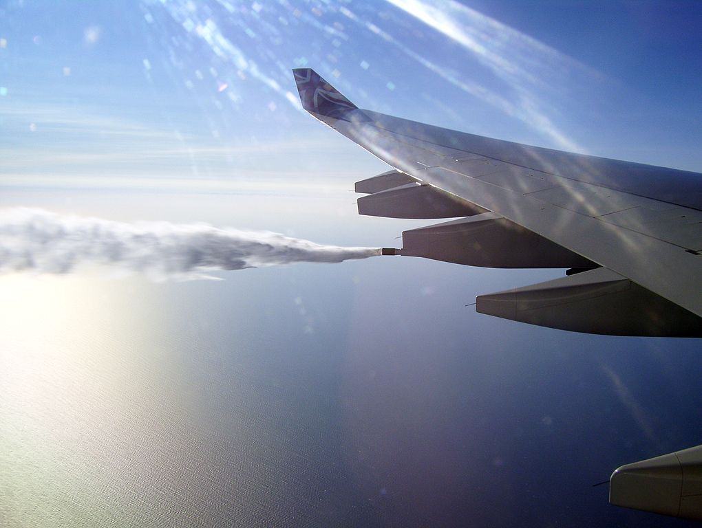 A plane dumping fuel as it cruises in the sky