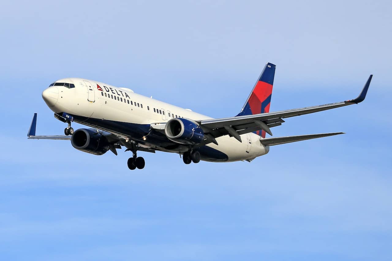 A Delta plane flying in blue skies