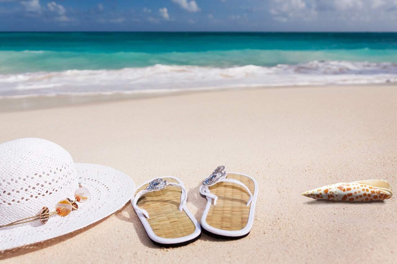 Flip flops and a hat on the sand on a beach
