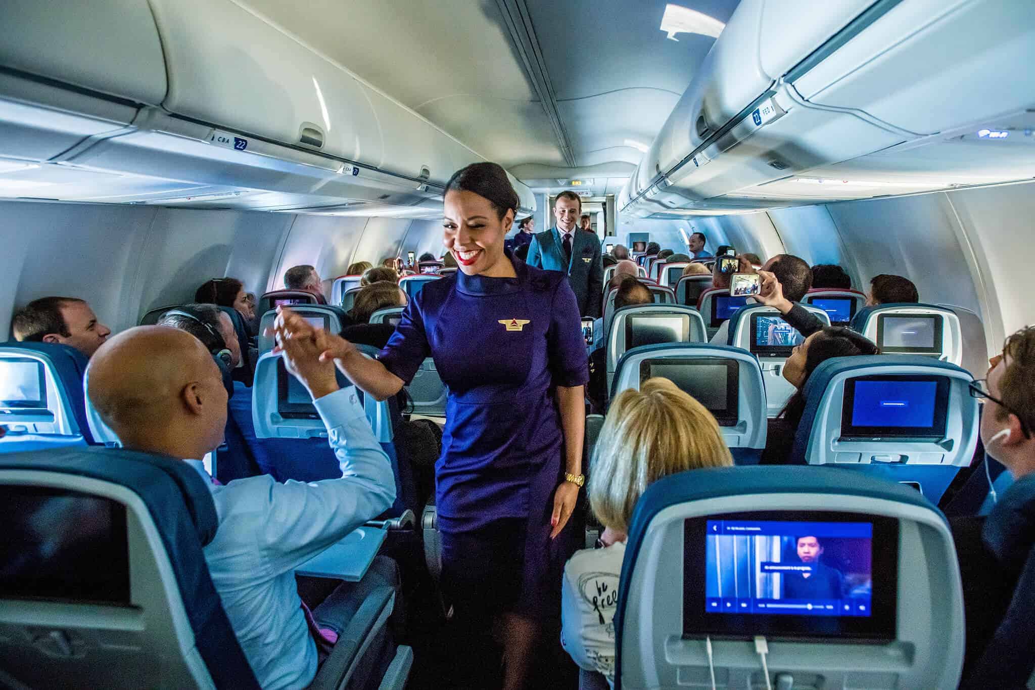 A flight attendant giving a passenger a high five