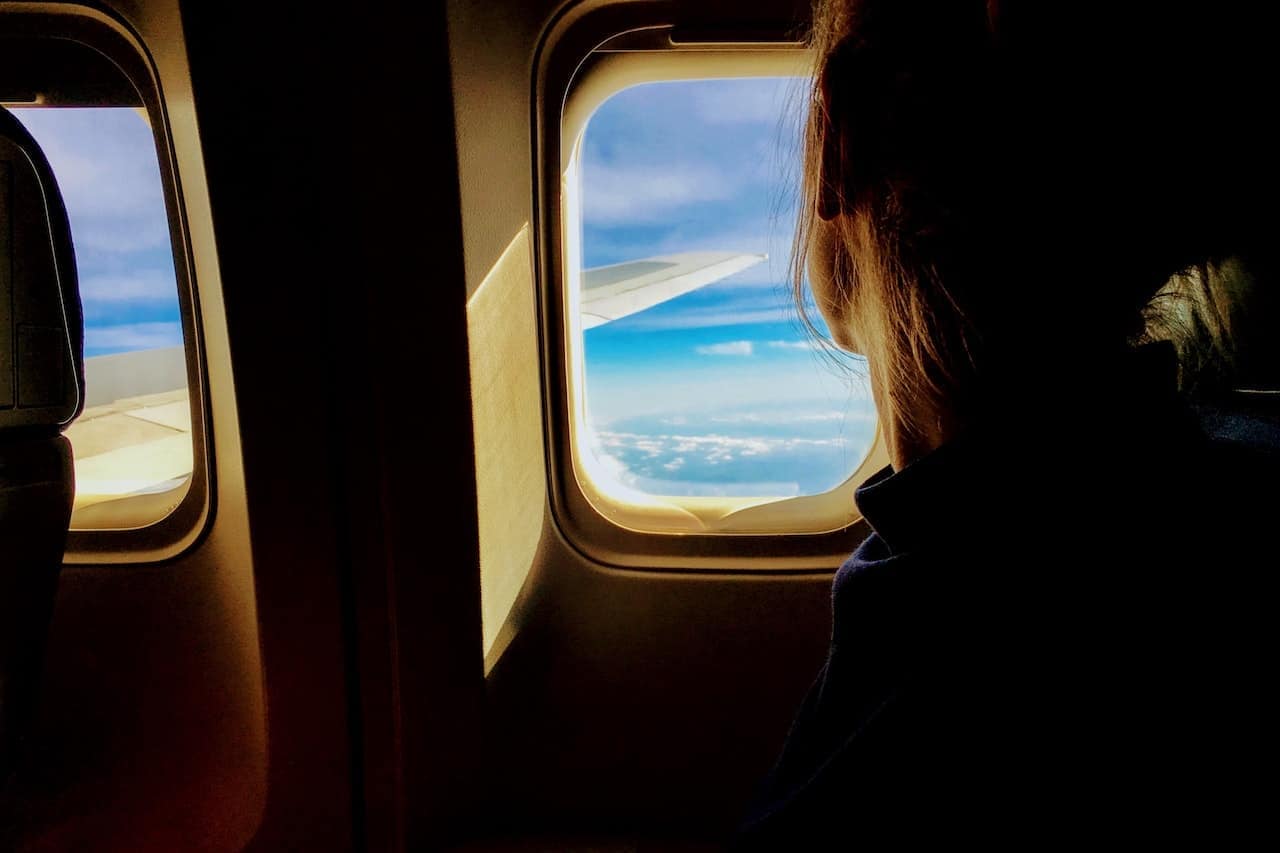 woman looking outside a plane window