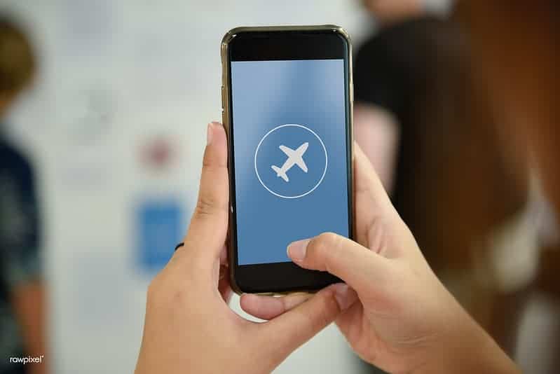 woman holding a phone and texting on a plane