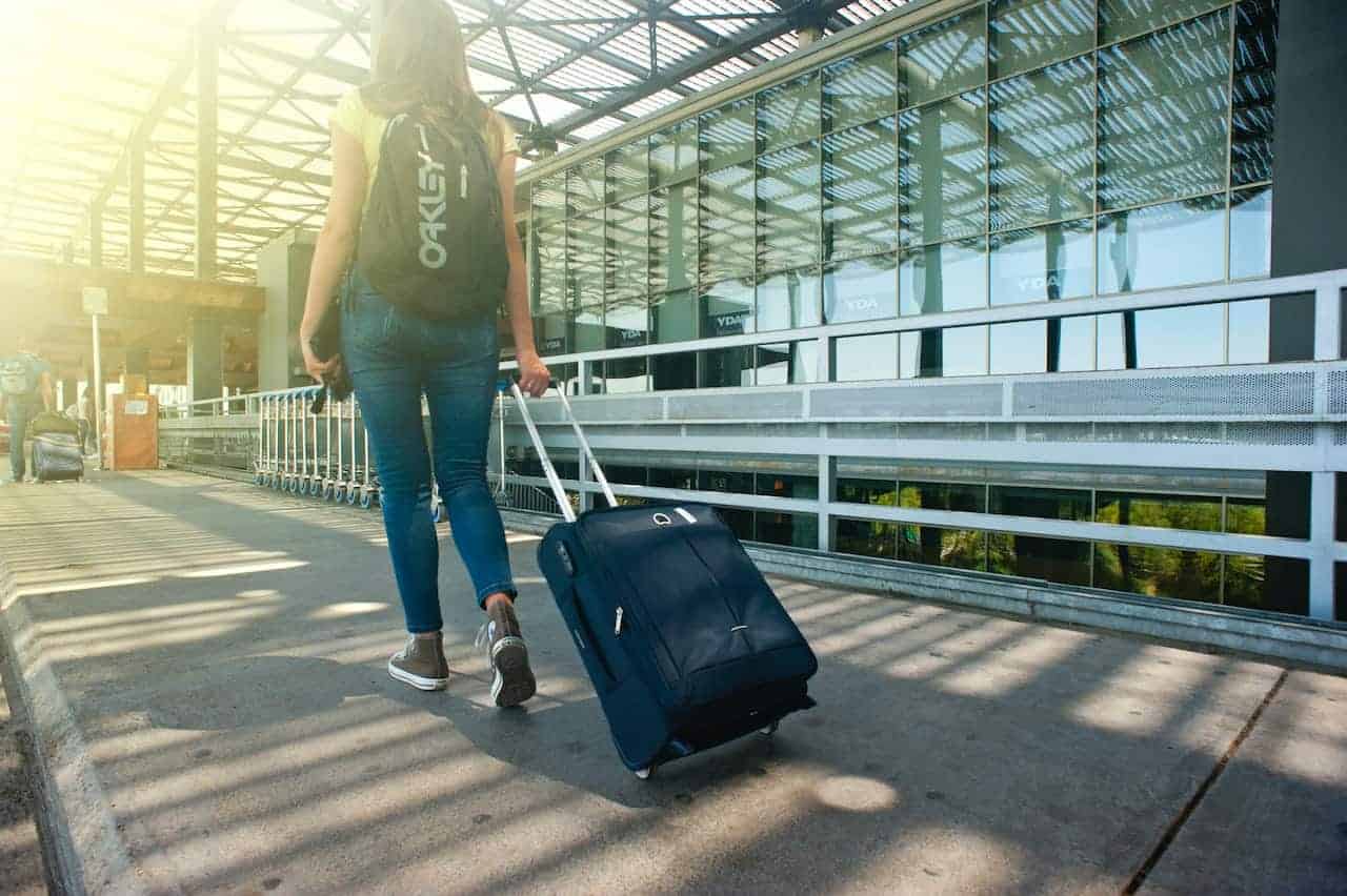 Woman wheeling her suitcase outside the terminal